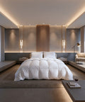 Luxuriöses Hotelbett mit hochwertiger weißer Daunendecke und passenden Kopfkissen in einem modernen, hellen Schlafzimmer.