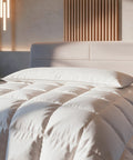 HANSE Premium Seitenschläferkissen auf Hotelbett mit weißer Daunendecke vor Holzlamellen-Wand