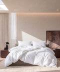 Luxuriöse federfreie Bettdecke auf modernem Hotelbett in hellem Schlafzimmer mit hochwertigem Ambiente.