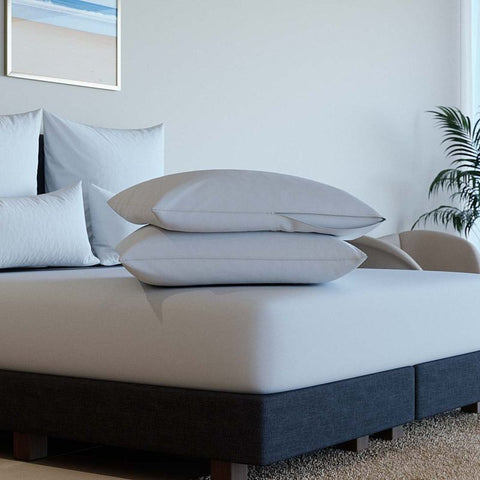 Detailansicht von zwei weißen Kissenschonbezügen auf einem modernen Bett, mit glatter Oberfläche und hochwertiger Verarbeitung für optimalen Kissenschutz