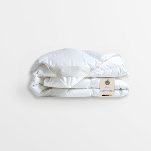 Weiße natürliche Daunendecke von Hanse Premium mit hochwertiger Steppung und elegantem Produktetikett auf hellem Hintergrund