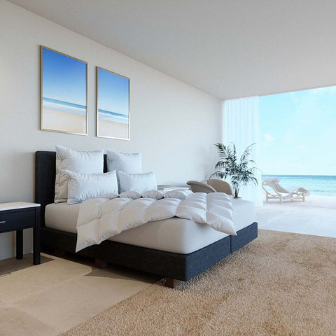 Modernes Schlafzimmer mit Halbdaunendecke und passenden Kissen in heller Einrichtung mit Meerblick